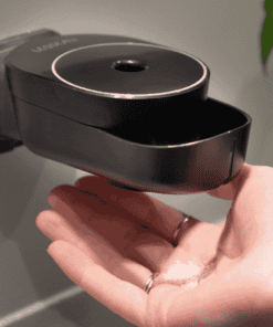 Handmatige zeepdispenser van Lesseau in zwart met plasticvrije zeepbar in hand