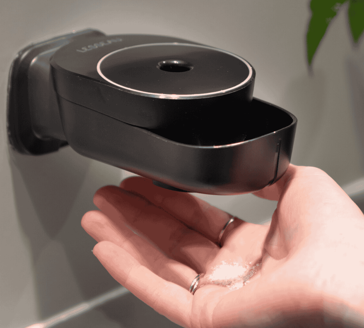 Handmatige zeepdispenser van Lesseau in zwart met plasticvrije zeepbar in hand