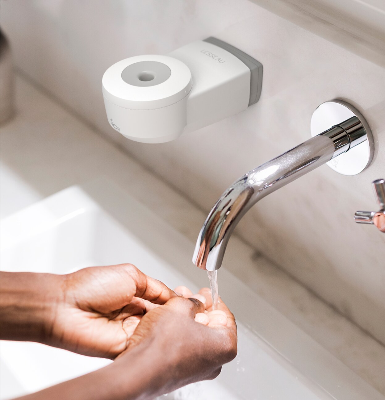 Persoon die handen wast in wasbak met zeepdispenser en handzeep van Lesseau